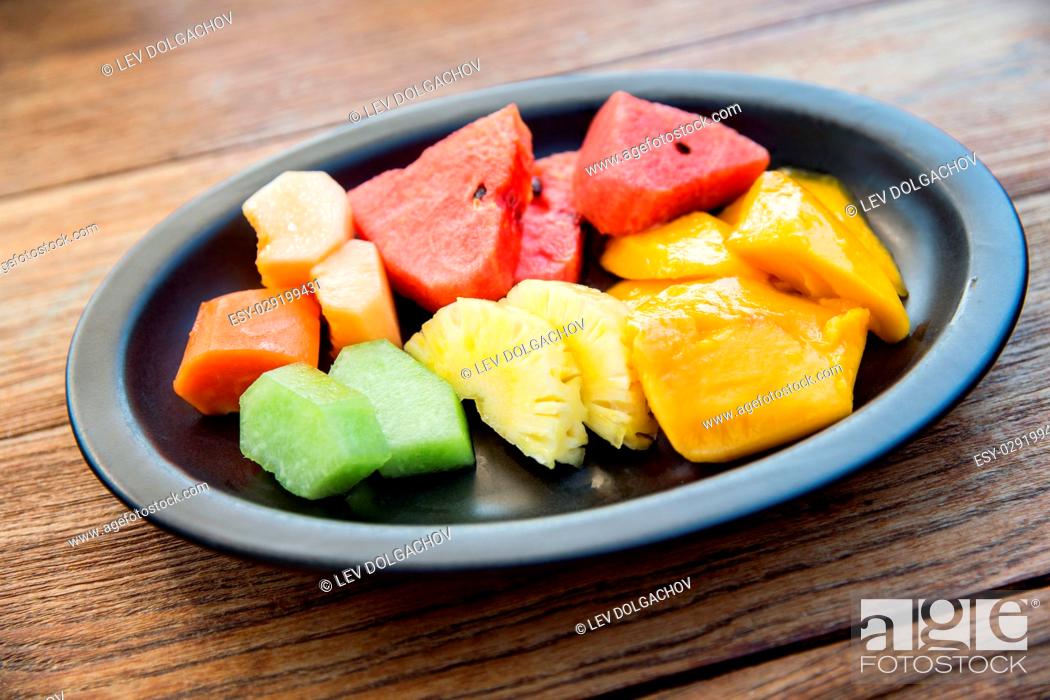 Stock Photo: food, eco, bio and summer holidays concept - still life with exotic tropical fruits in bowl.