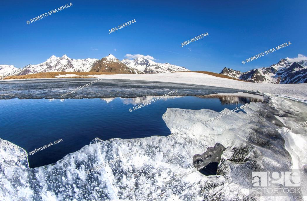 Stock Photo: Lake Andossi surrounded by ice and snow during the spring thaw Madesimo Spluga Valley Sondrio Valtellina Lombardy Italy Europe.