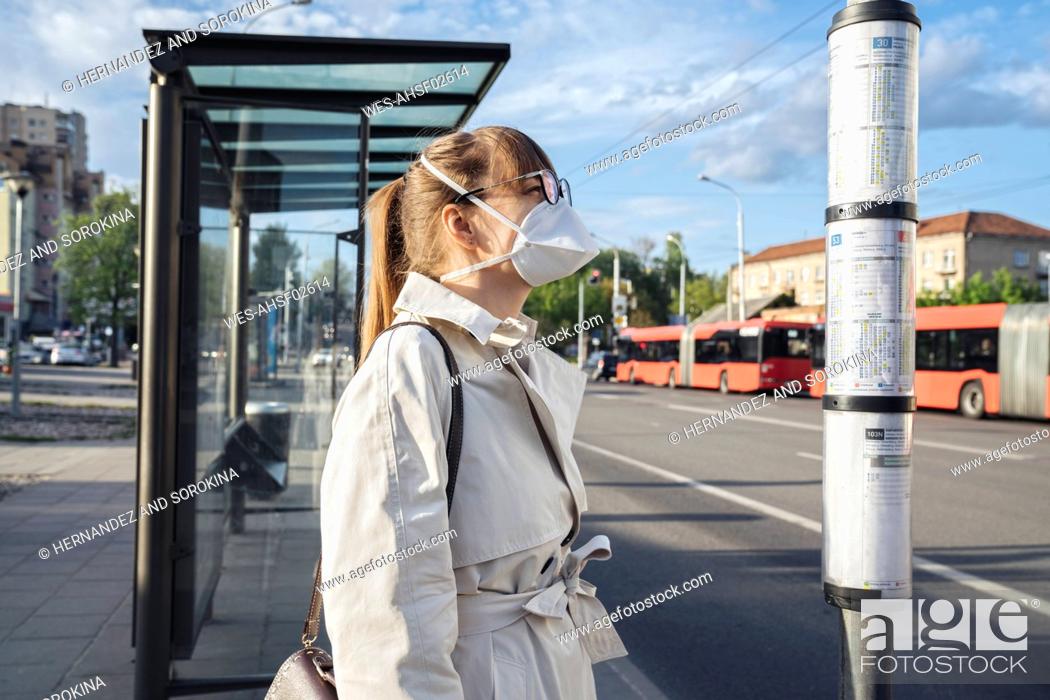 Stock Photo: Woman wearing face mask checking schedule of public transport in the city.