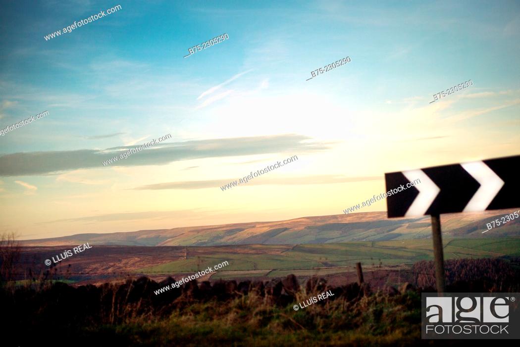 Imagen: North Yorkshire landscape at sunset, with a traffic sign in the foreground with directional arrows to the right. North Yorkshire, England, UK.