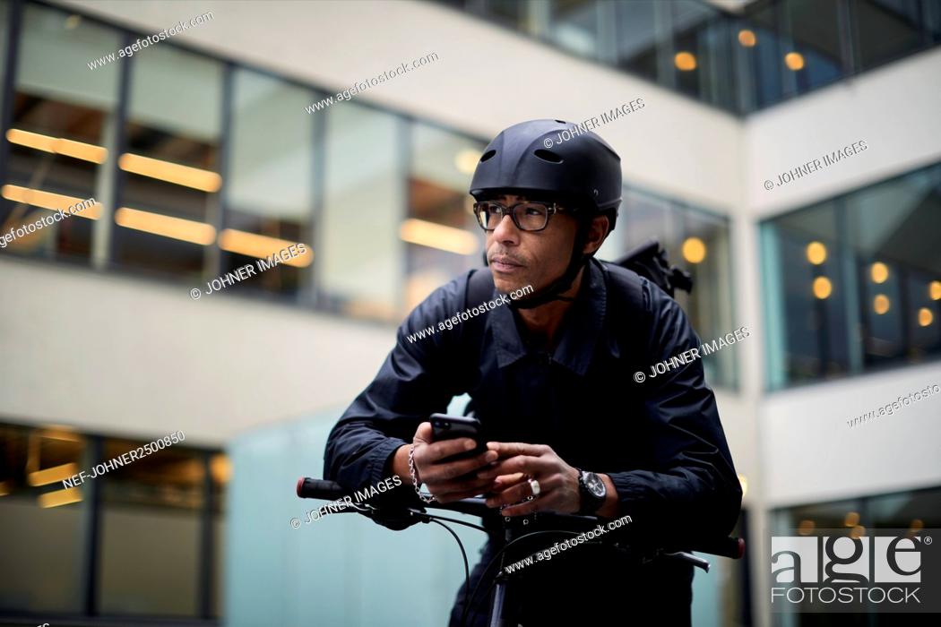 Stock Photo: Bicycle courier using cell phone.