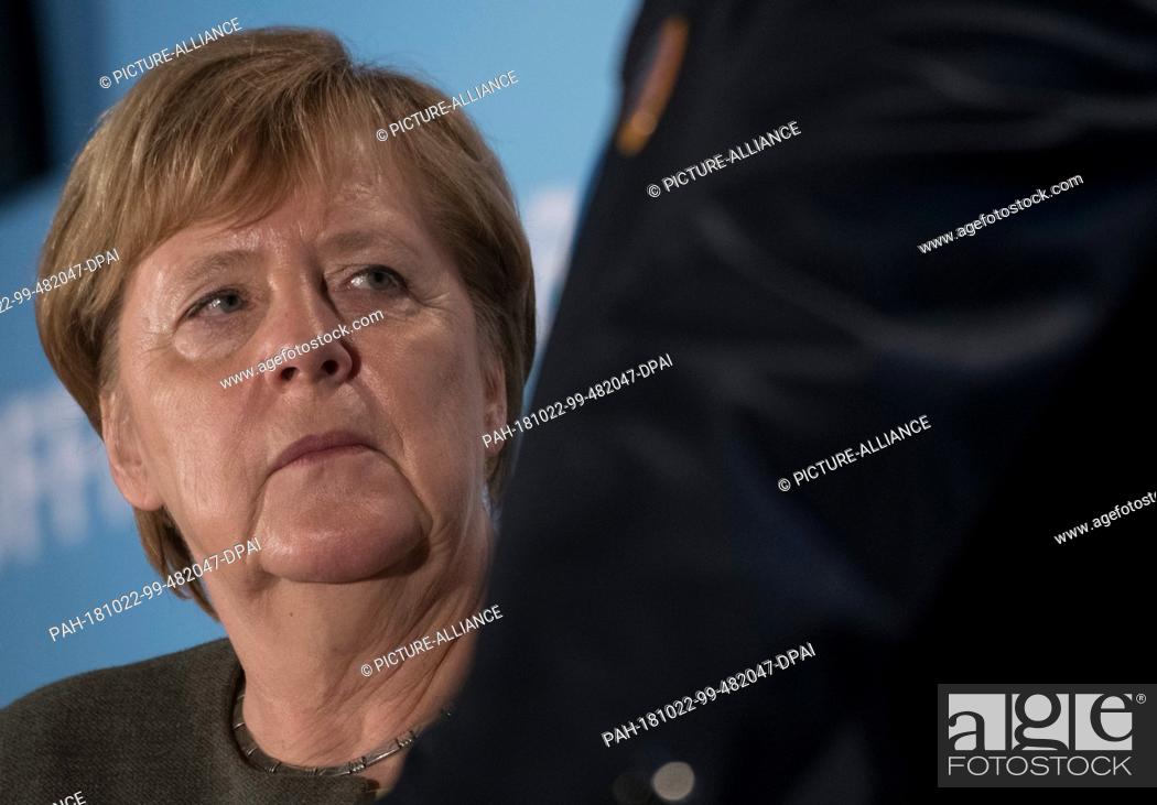 Stock Photo: 22 October 2018, Hessen, Ortenberg: Chancellor Angela Merkel (CDU) is standing in the marquee on the cold market. A new state parliament will be elected in.