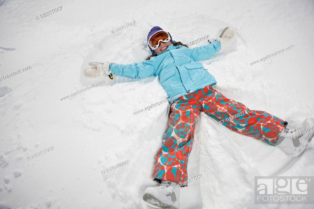 Stock Photo: Girl 10-11 in ski gear doing snow angel.