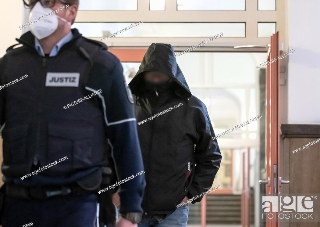 Stock Photo: 20 January 2021, North Rhine-Westphalia, Dortmund: The defendant comes across the corridor of the district court accompanied by a court employee.