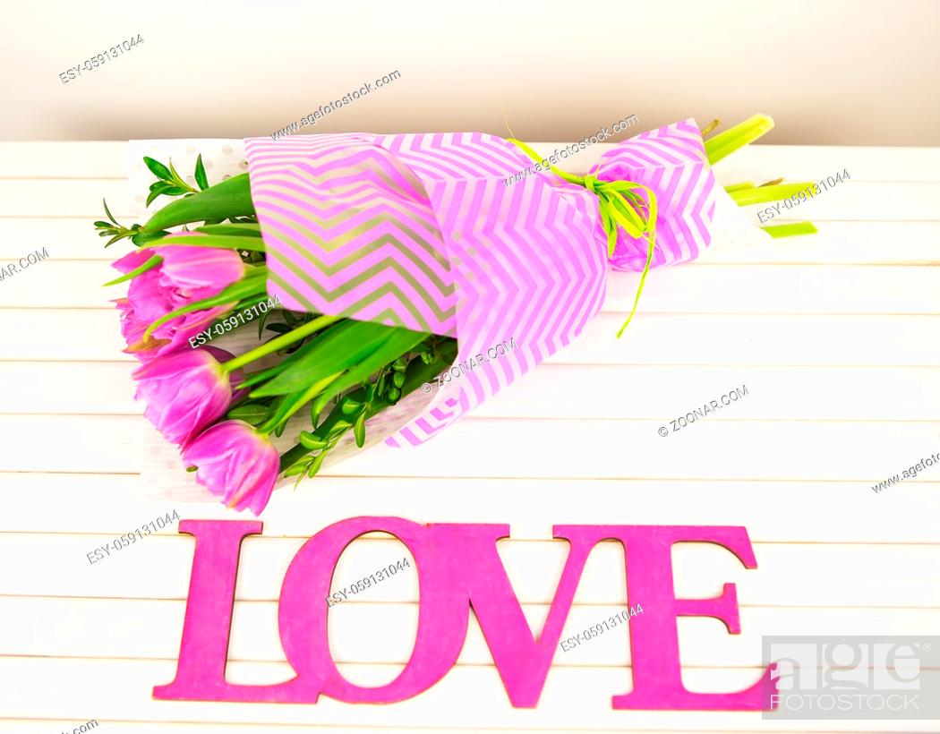 Stock Photo: bouquet of purple tulips on white table, wooden letters love.