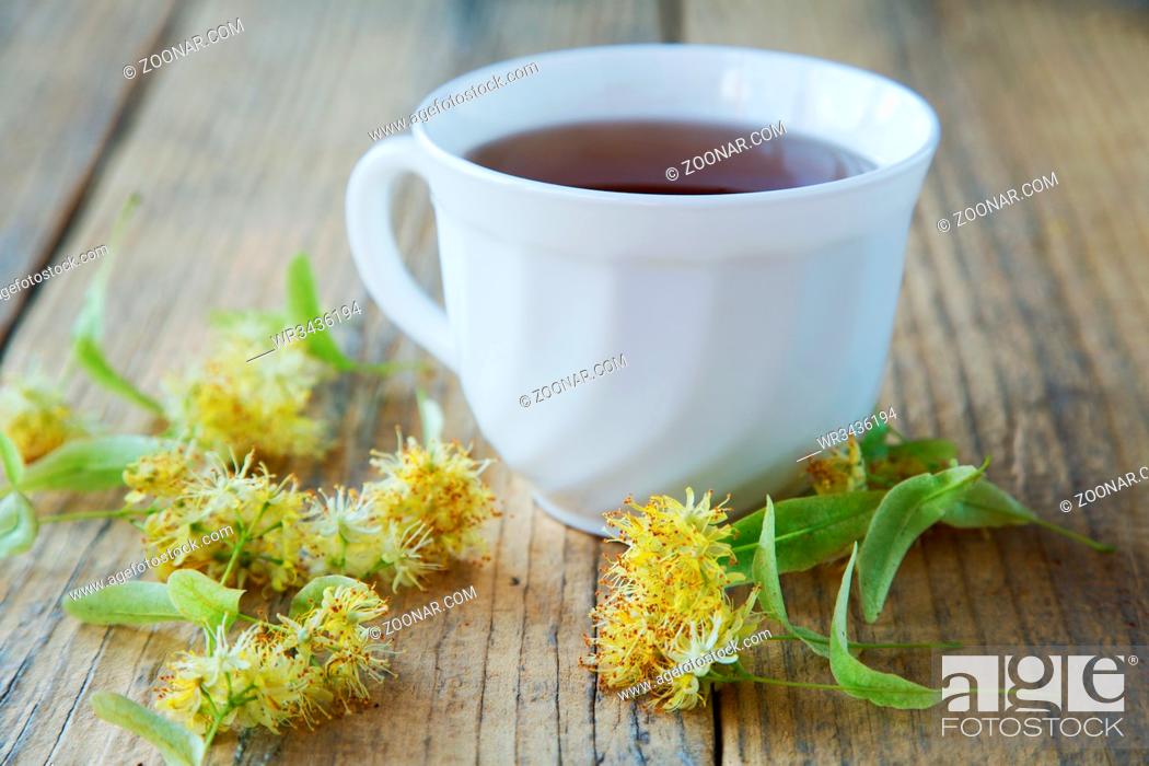 Stock Photo: cup of tea with linden flowers on a rustic table.