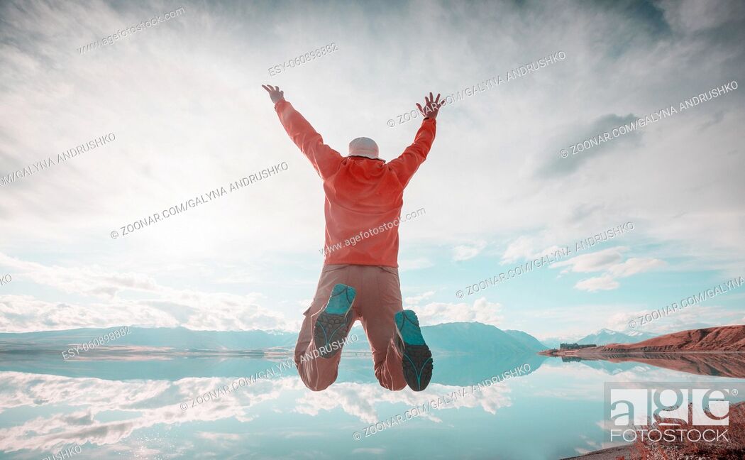Stock Photo: Jumping man above mountains lake.