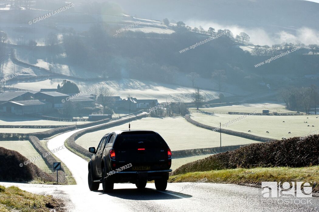 Stock Photo: A motorist drives through a frosty landscape along the road between Aberedw and Builth Wells, Powys, UK.