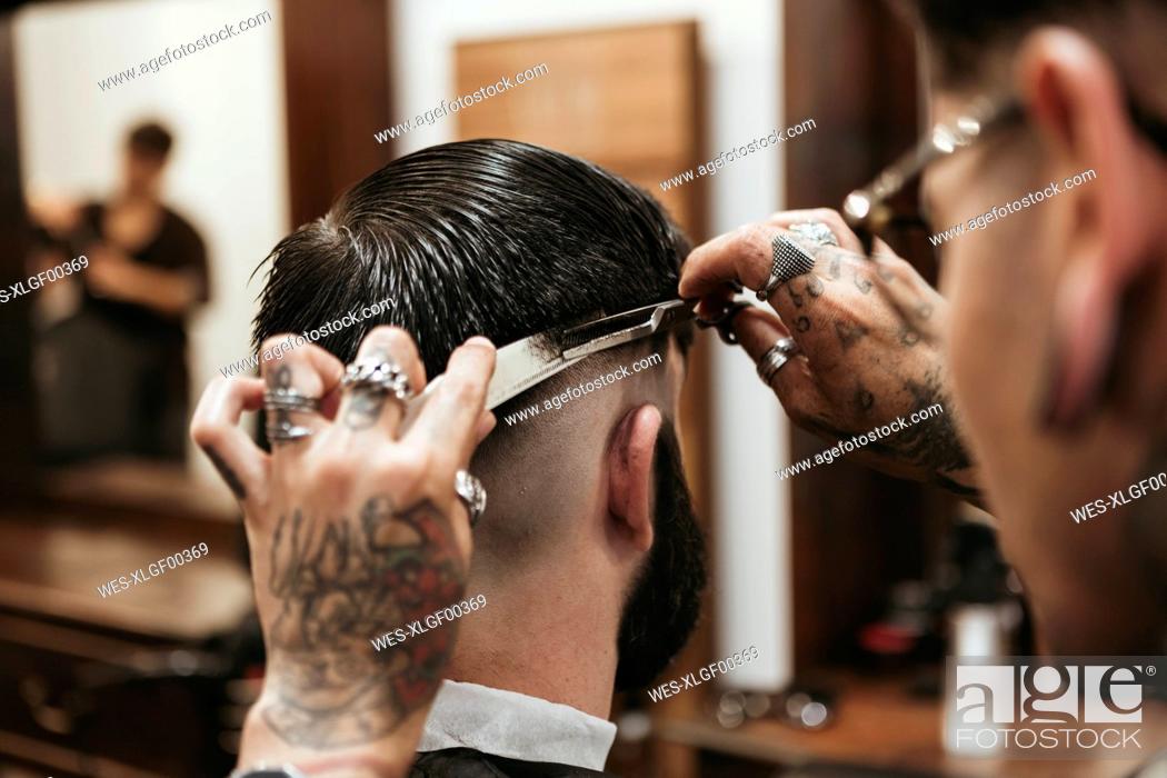Stock Photo: Barber cutting man's hair at salon.