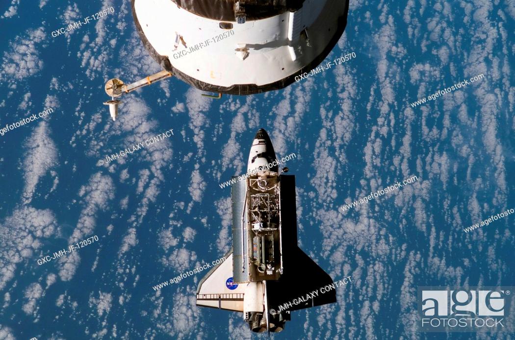 Stock Photo: Backdropped by a blue and white Earth, the Space Shuttle Atlantis approaches the International Space Station during STS-117 rendezvous and docking operations.