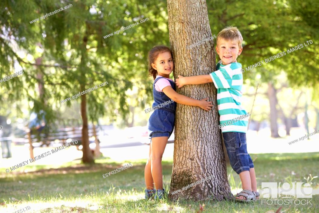 Stock Photo: Two Children Hugging Tree In Park.