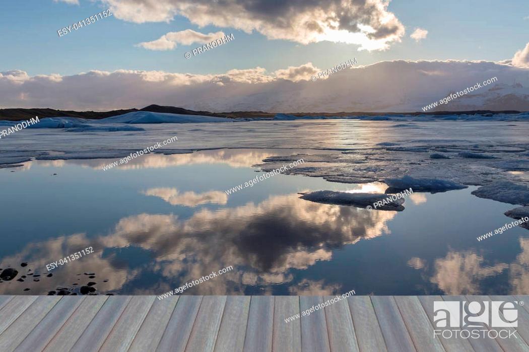 Stock Photo: Opening wooden floor, Beauty reflection winter lagoon with sun behind cloud, Iceland natural landscape.