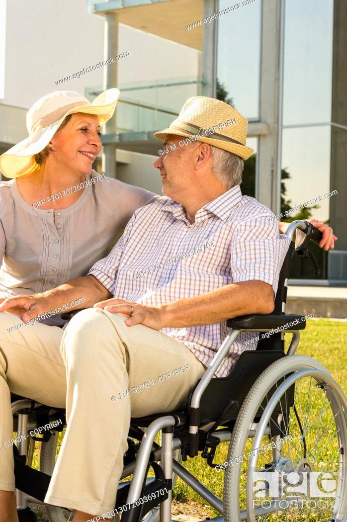 Stock Photo: Retirement disabled man with wife sitting outdoors.