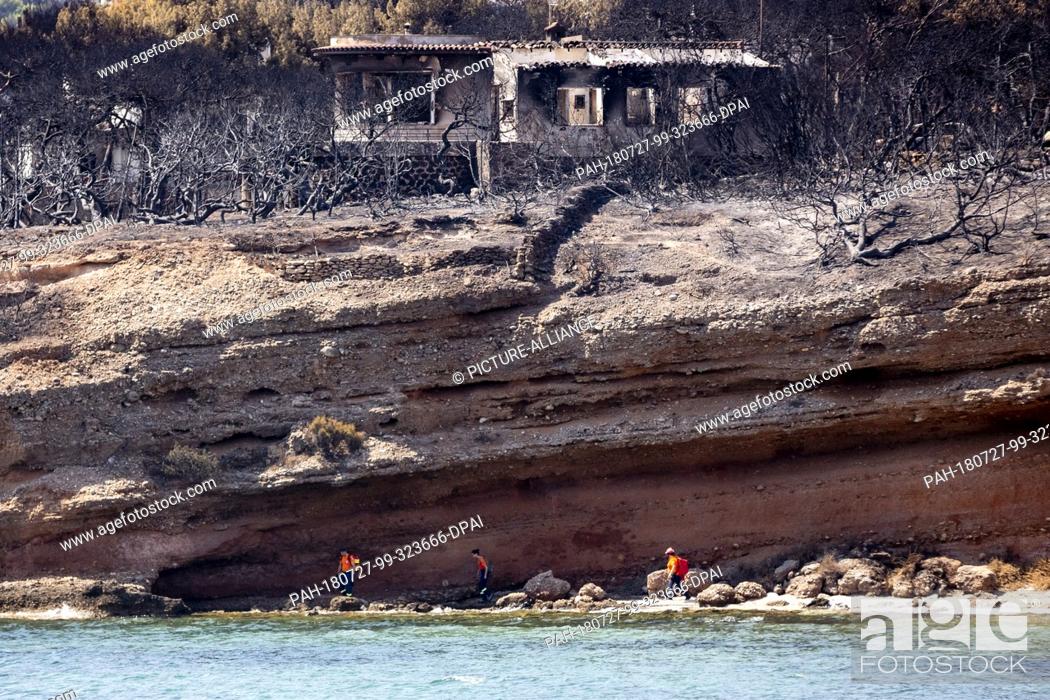 Stock Photo: 27 July 2018, Greece, Mati: Volunteers from EVOLSAR (European Association of Civil Protection Volunteer Teams) search the coast off Mati for further victims.