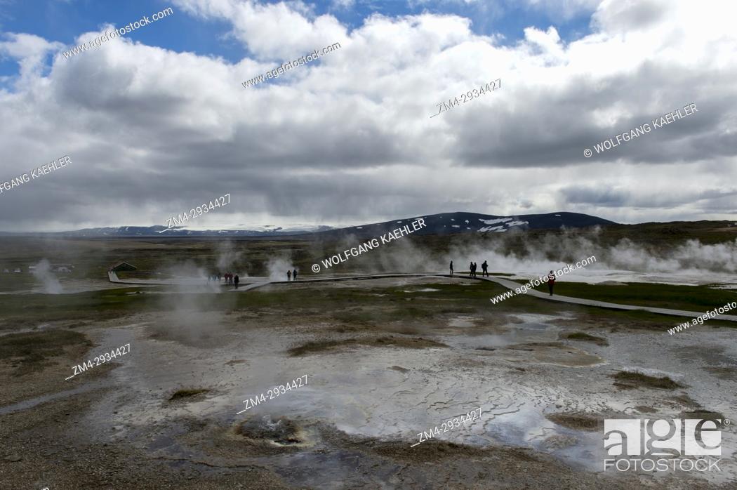 Stock Photo: People are walking on boardwalks through the hot springs at Hveravellir, a geothermal area of fumaroles, and multicolored hot pools in the central highlands of.