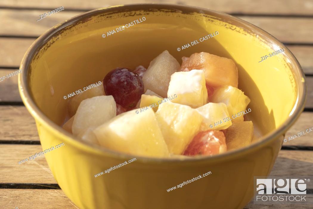 Stock Photo: Top view of white bowl full of fruit salad containing strawberries, grapes, orange, kiwi, pineapple and apple.