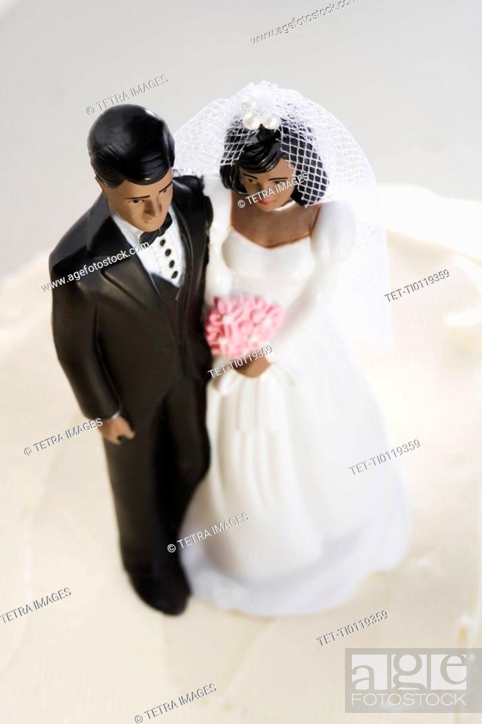 Stock Photo: Bride and groom on top of wedding cake.