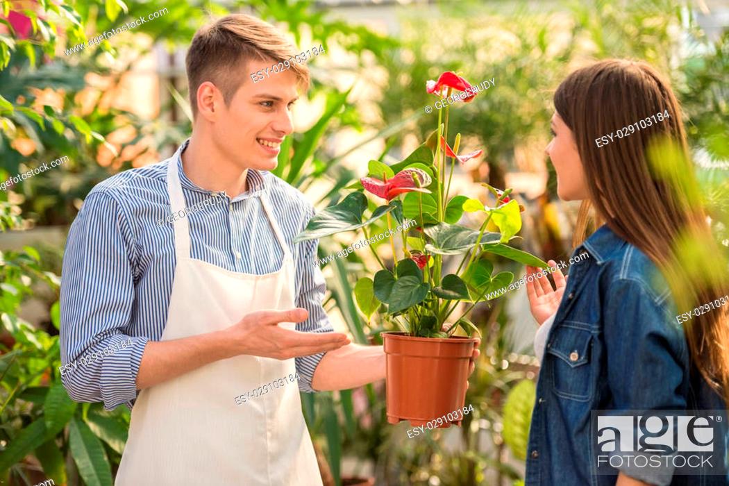 Stock Photo: Male florist helping young female choosing the right flower.