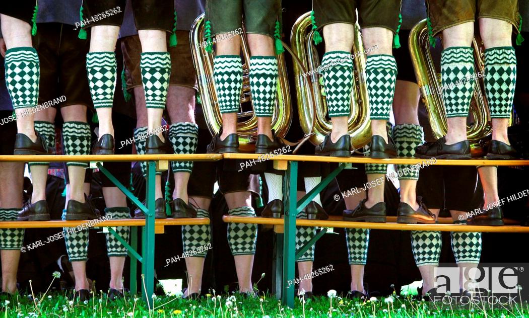 Stock Photo: Musicians of the band Garmisch wearing traditional Bavarian costumes stand on beer benches and tables to take a group photo in the spa park of.