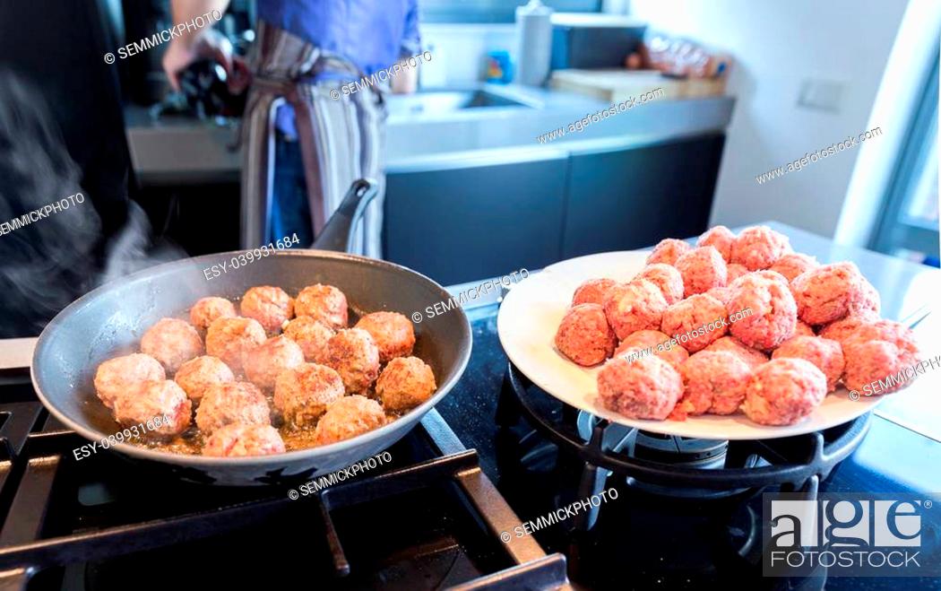 Stock Photo: Fried and raw meatballs on the stove.