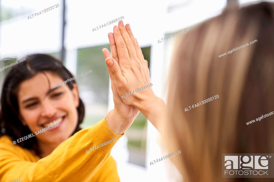 Stock Photo: Shot of Latin-American businesswoman high-fiving her co-worker in outdoors office.