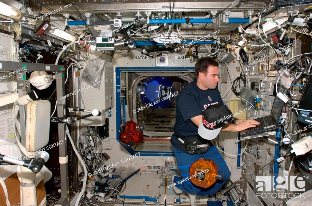 Stock Photo: Astronaut Greg Chamitoff, Expedition 17 flight engineer, uses a computer while doing a check of the Synchronized Position Hold, Engage, Reorient.