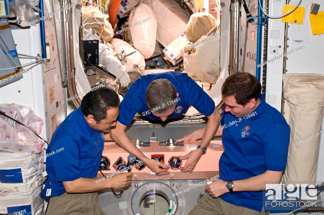 Stock Photo: In the Unity node, Expedition 29 crew members add the Expedition 29 patch to the growing collection of insignias representing crews who have worked on the.