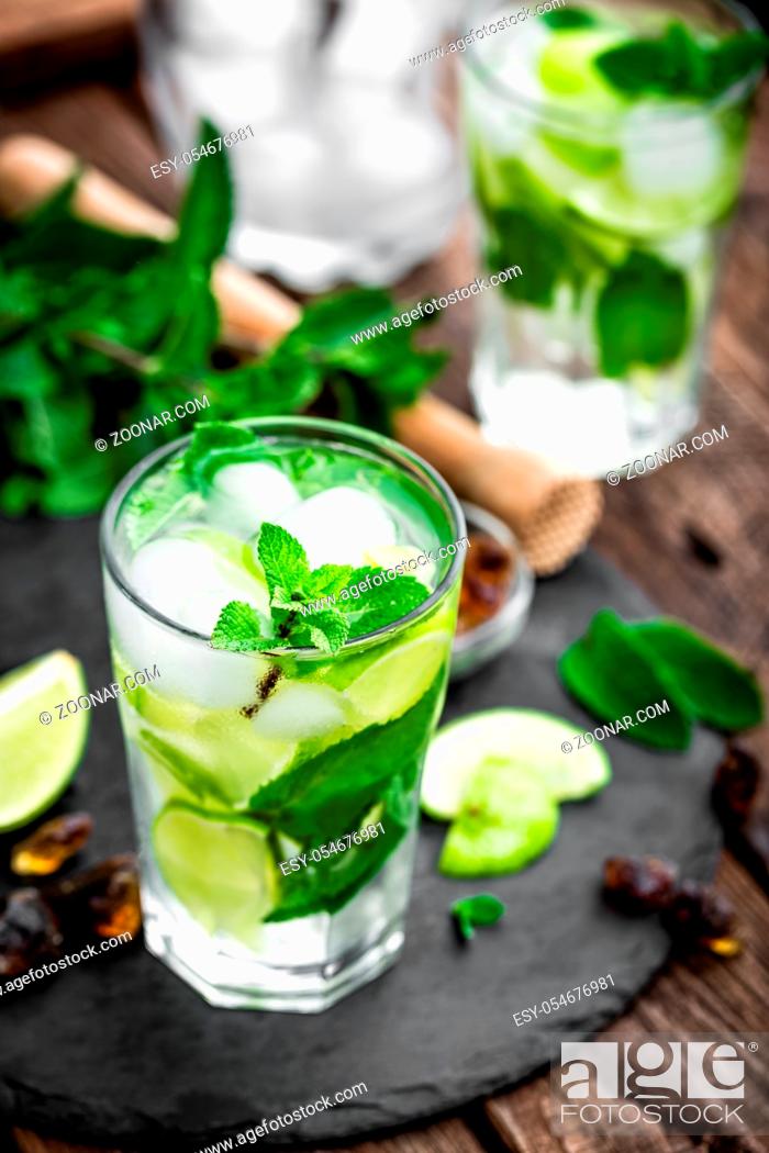 Stock Photo: Refreshing mint cocktail mojito with rum and lime, cold drink or beverage with ice on black background.