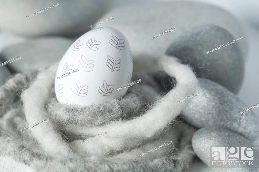 Stock Photo: Easter egg in nest with pebbles, close up.
