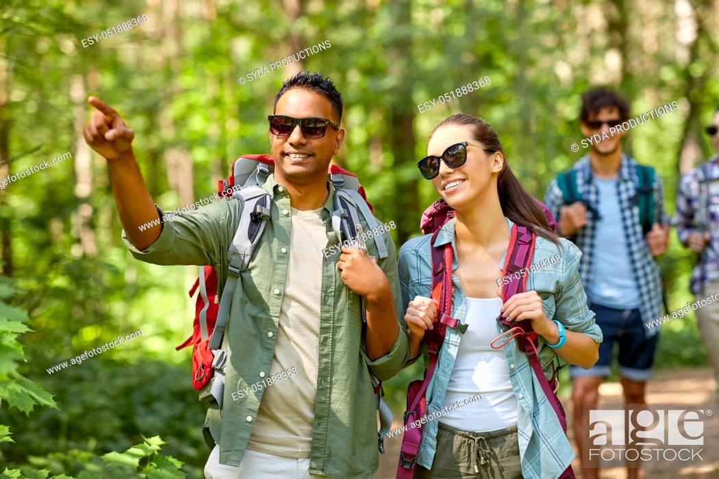 Stock Photo: group of friends with backpacks hiking in forest.