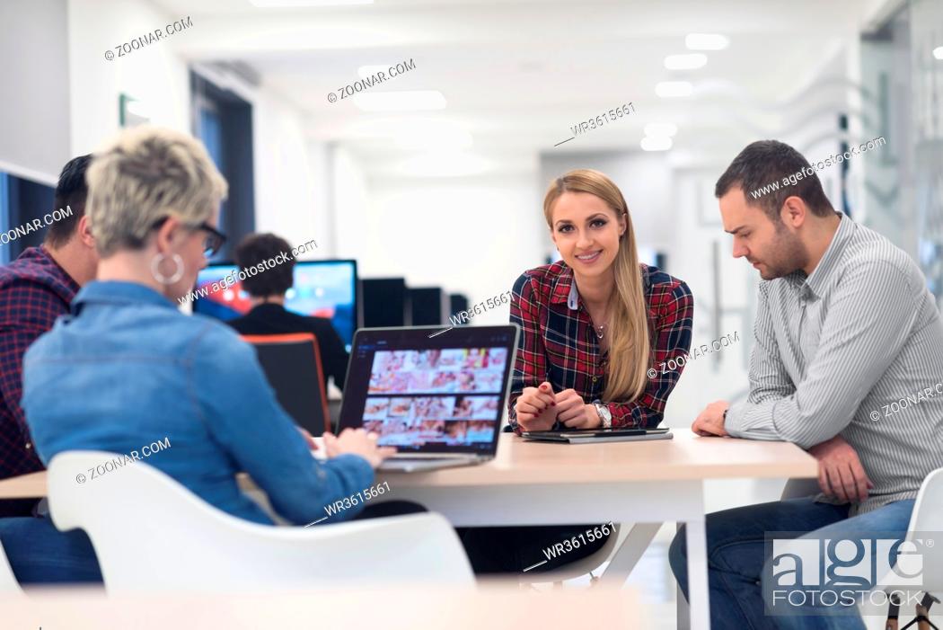 Stock Photo: startup business team on meeting in modern bright office interior brainstorming, working on laptop and tablet computer.
