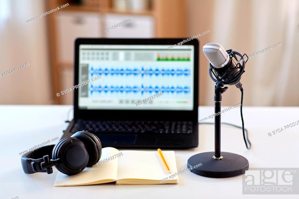 Imagen: microphone, laptop, headphones, notebook on table.
