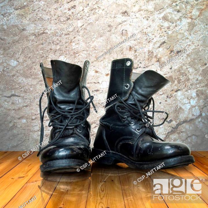 Stock Photo: old black boot on wood floor.