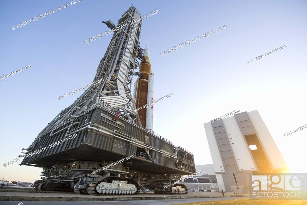 Stock Photo: NASA’s Space Launch System (SLS) rocket with the Orion spacecraft aboard is seen atop a mobile launcher as it rolls out of High Bay 3 of the Vehicle Assembly.