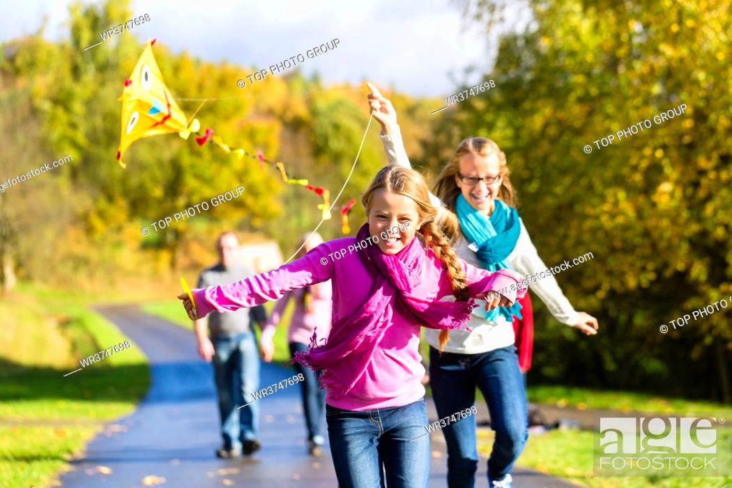 Stock Photo: Family take walk in autumn forest flying kite.