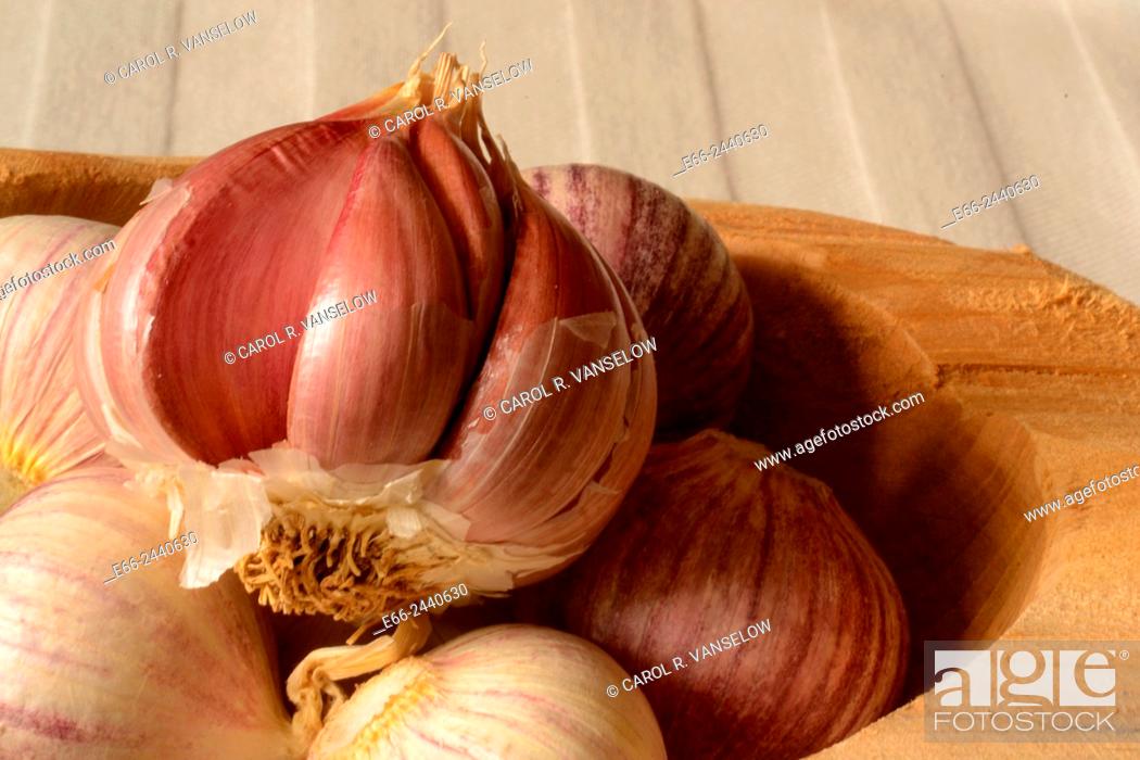 Stock Photo: Garlic bulbs (Allium sativum) in wooden bowl on table, with beige table cloth.