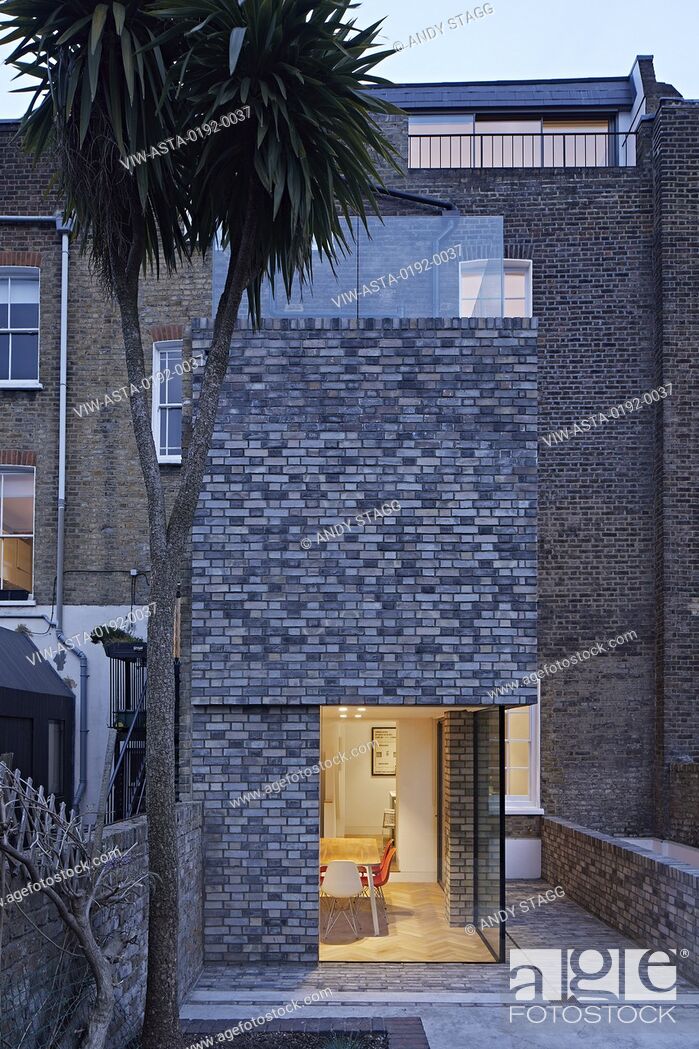 Stock Photo: Dusk view of double-height rear extension with corner window on ground level. Queens House, London, United Kingdom. Architect: Paul Archer Design - Architects &.