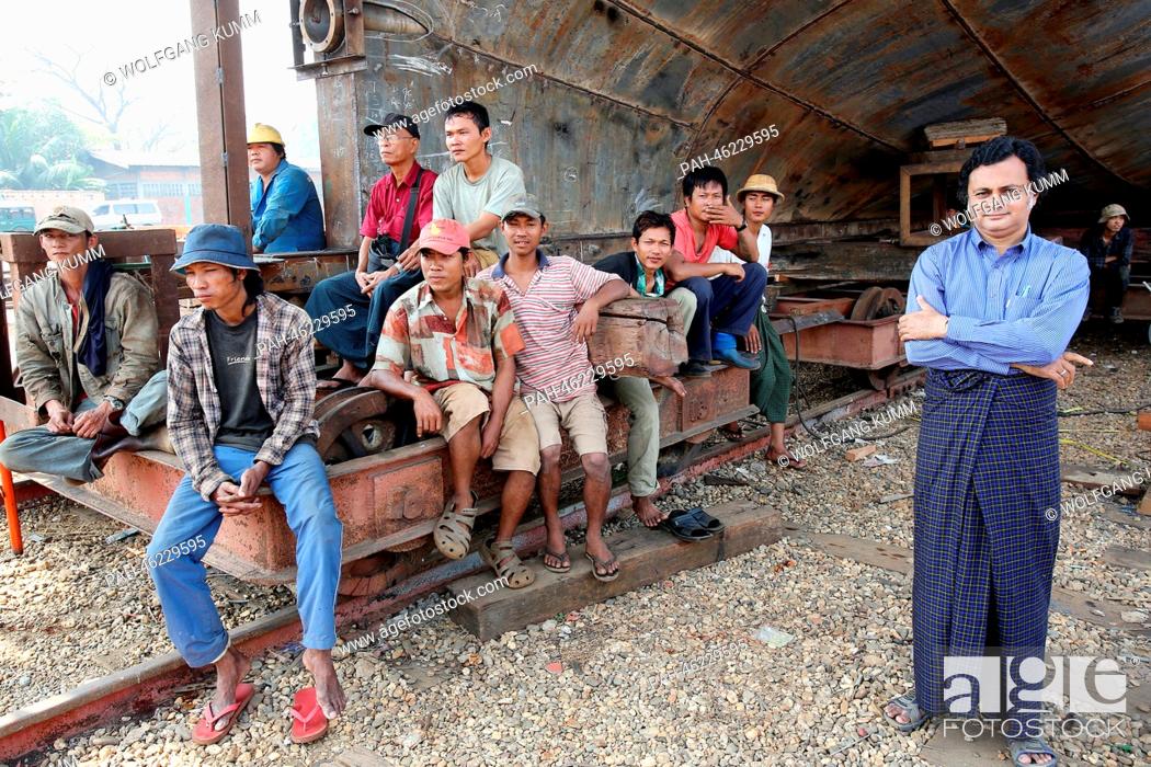 Stock Photo: Dock workers sit in front of a vessel under construction during a baptism ceremony of a converted passanger boat, called the 'Swimming Doctors 2' (not in.