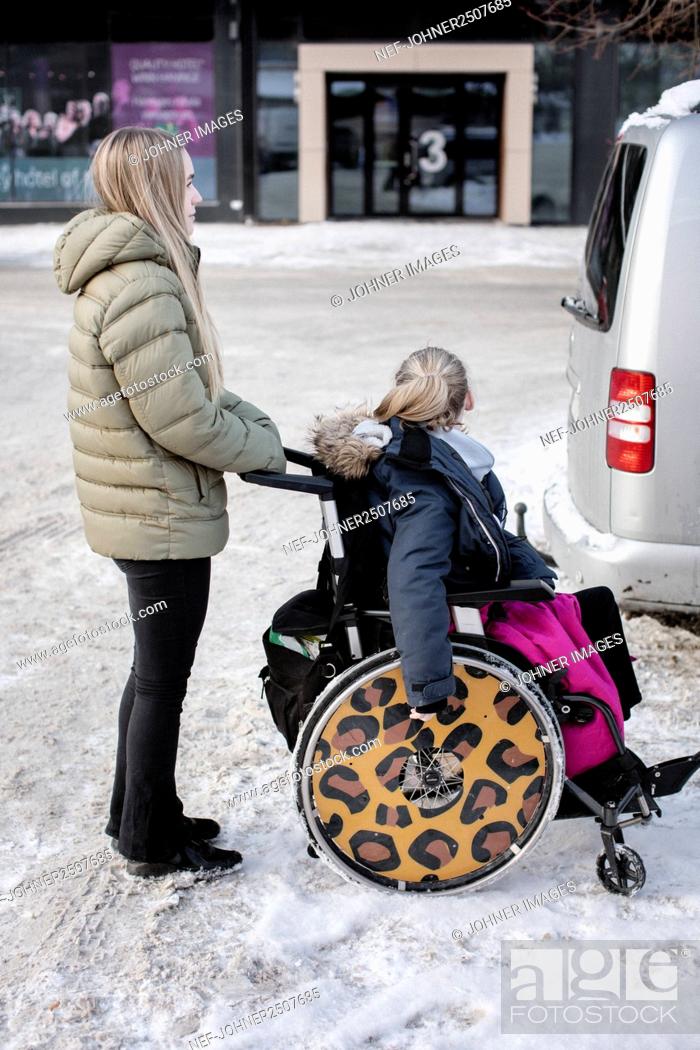 Imagen: Woman pushing girl on wheelchair.