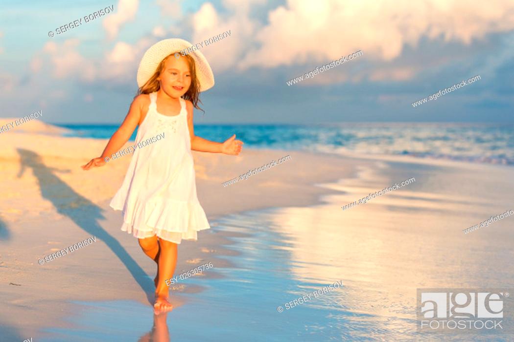 Stock Photo: Little girl walking on beautiful ocean beach.