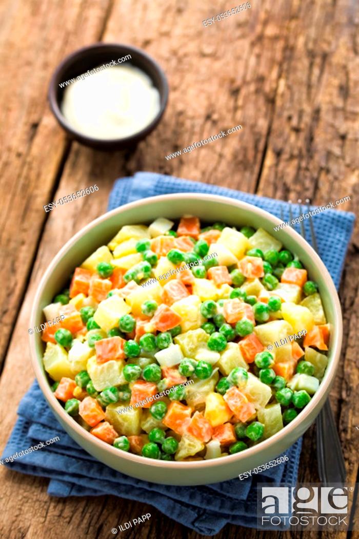 Stock Photo: Fresh homemade vegetarian Russian or Olivier salad made of potato, carrot, pea, hard-boiled egg and a mayonnaise dressing.