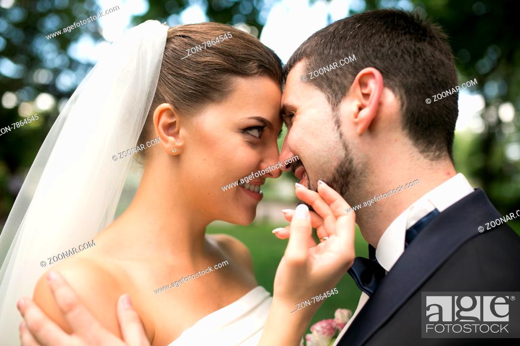Stock Photo: beautiful bride caress gently, the groom#39;s face in the park.
