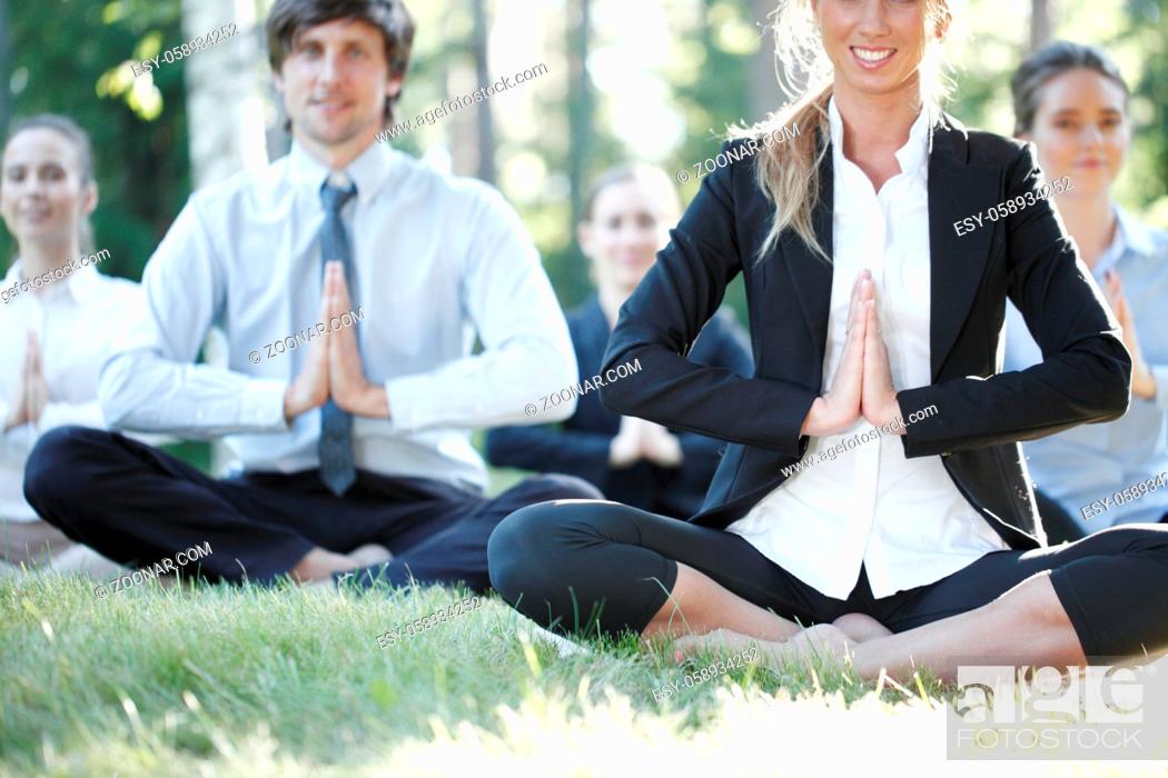 Stock Photo: Business people team practicing yoga in park.