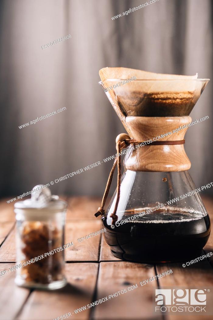Stock Photo: A tabletop scene with coffee running through a coffee maker and some rock candy on a wooden table.