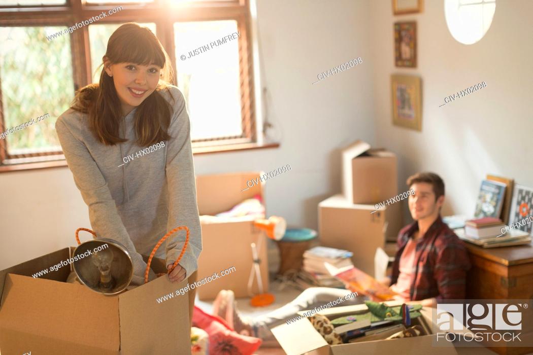 Stock Photo: Portrait smiling young couple unpacking moving boxes in apartment.