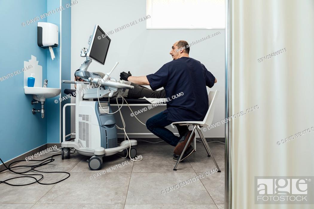Stock Photo: Doctor performing an ultrasound scan on a patient lying on a stretcher.