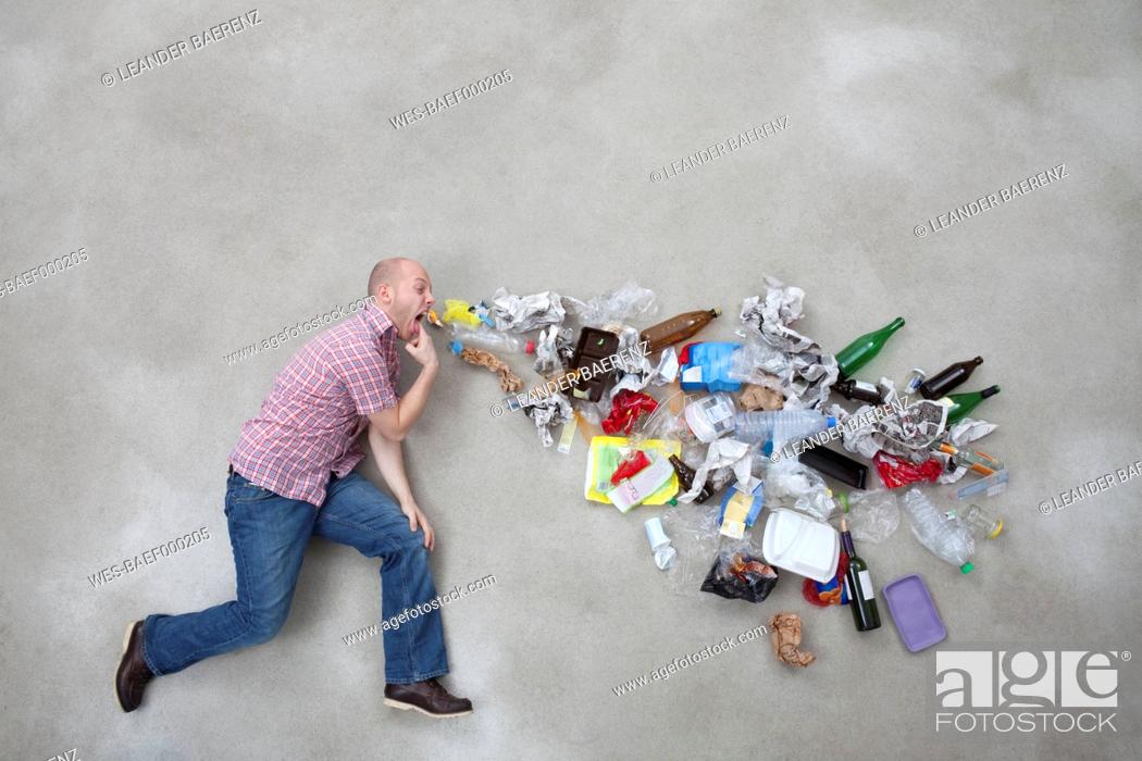 Stock Photo: Young man vomiting garbage.