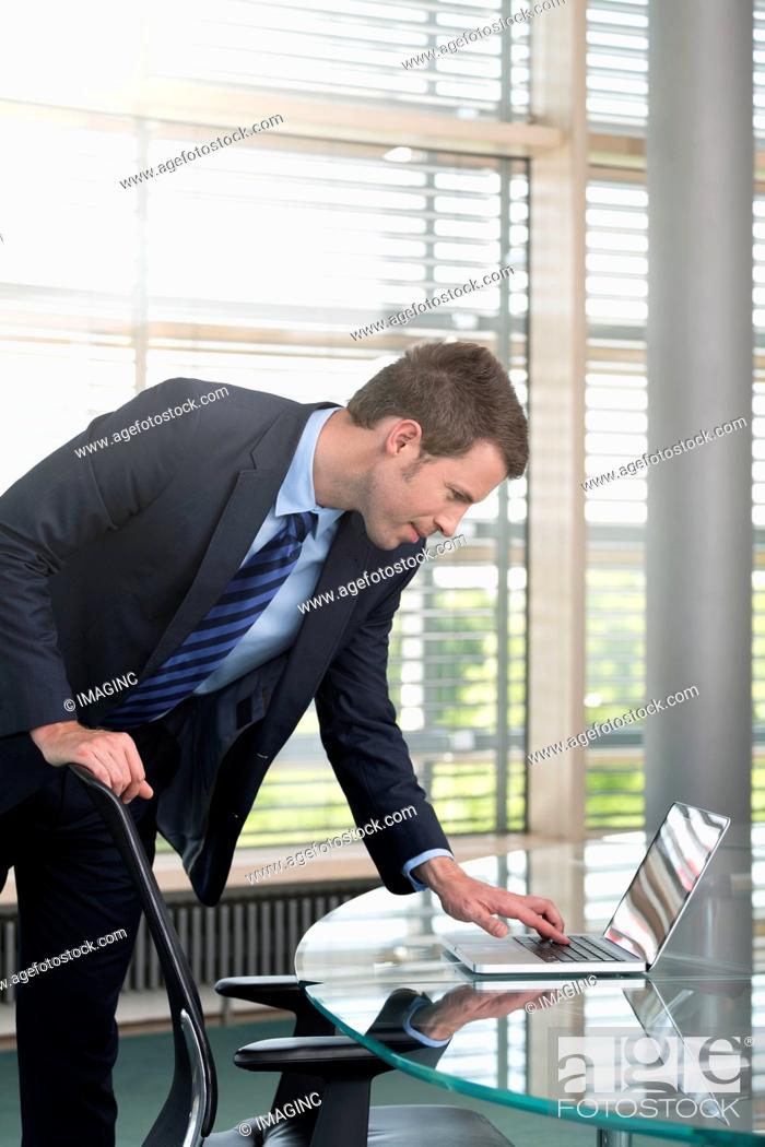 Stock Photo: Germany, Hannover, Businessman using laptop on conference table.