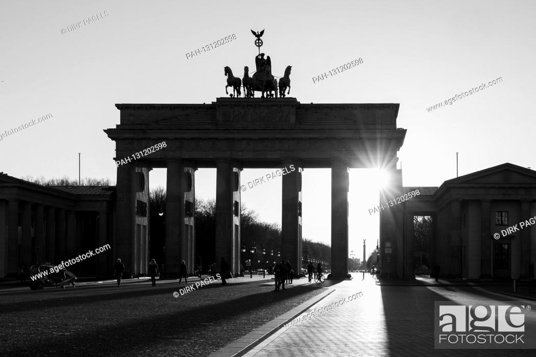 Stock Photo: 22.03.2020, the Brandenburg goal in Berlin on a late spring juice day in the low sun. The sun shines through the prophylaxis and creates a special mood of light.