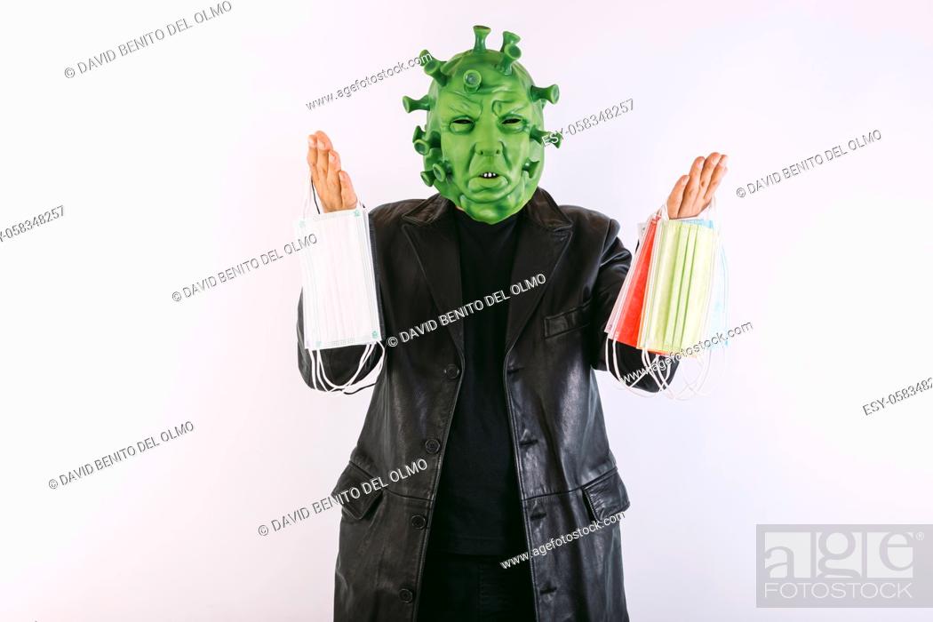 Stock Photo: Person disguised as a coronavirus with a latex mask - covid-19 virus, wearing a black leather frock coat and a black t-shirt.